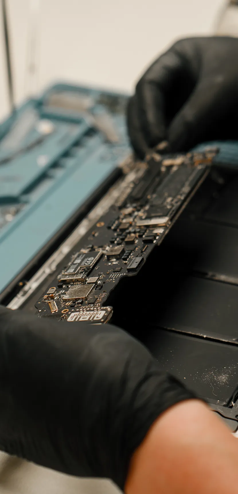 a person holding a circuit board MacBook Termal Macun Değişimi